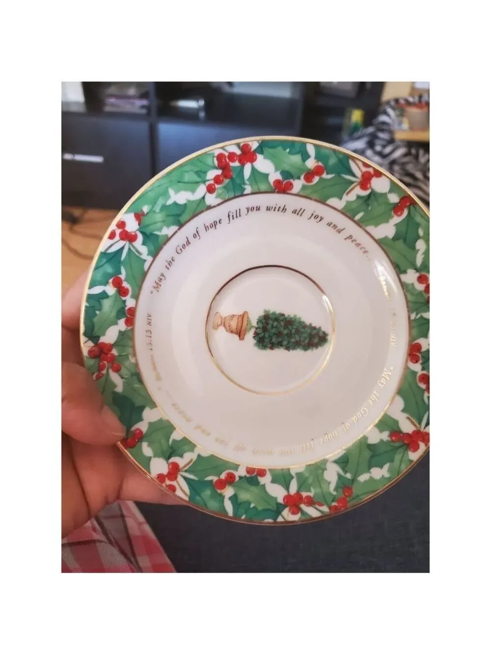 vintage teacup and saucer set features a festive holly pattern.